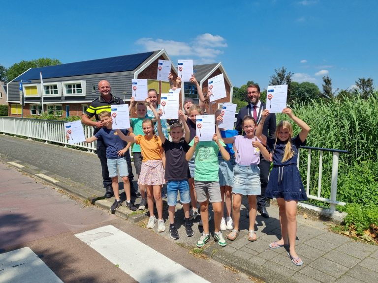 Leerlingen zwaaien met hun net behaalde diploma.