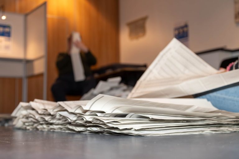 Afbeelding van stembiljetten in een stembureau.