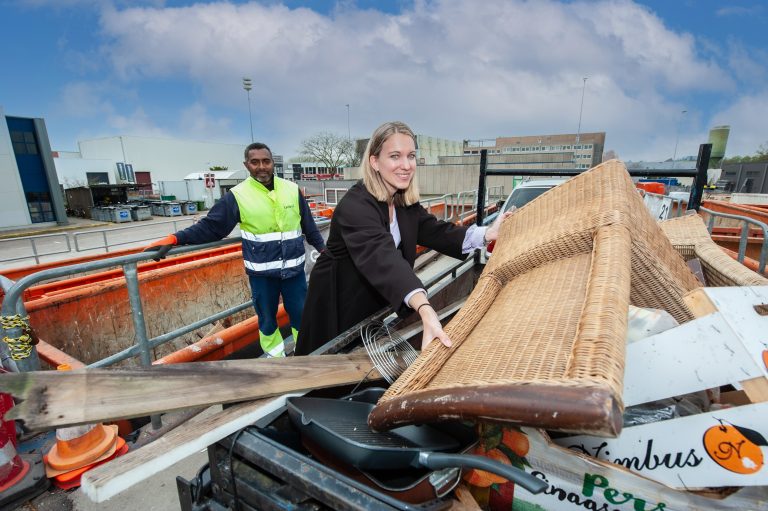 Mevrouw die spullen wegbrengt naar de milieustraat.